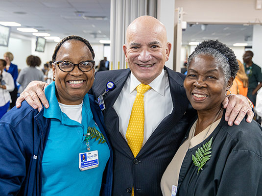 A man and two woman who are health professionals smiling at the camera