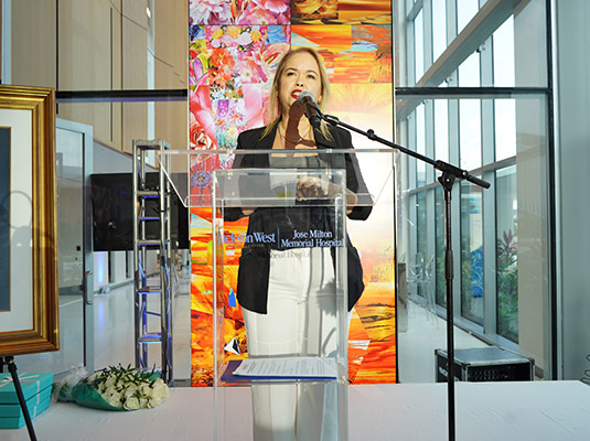 Woman in front of a podium speaking into a microphone