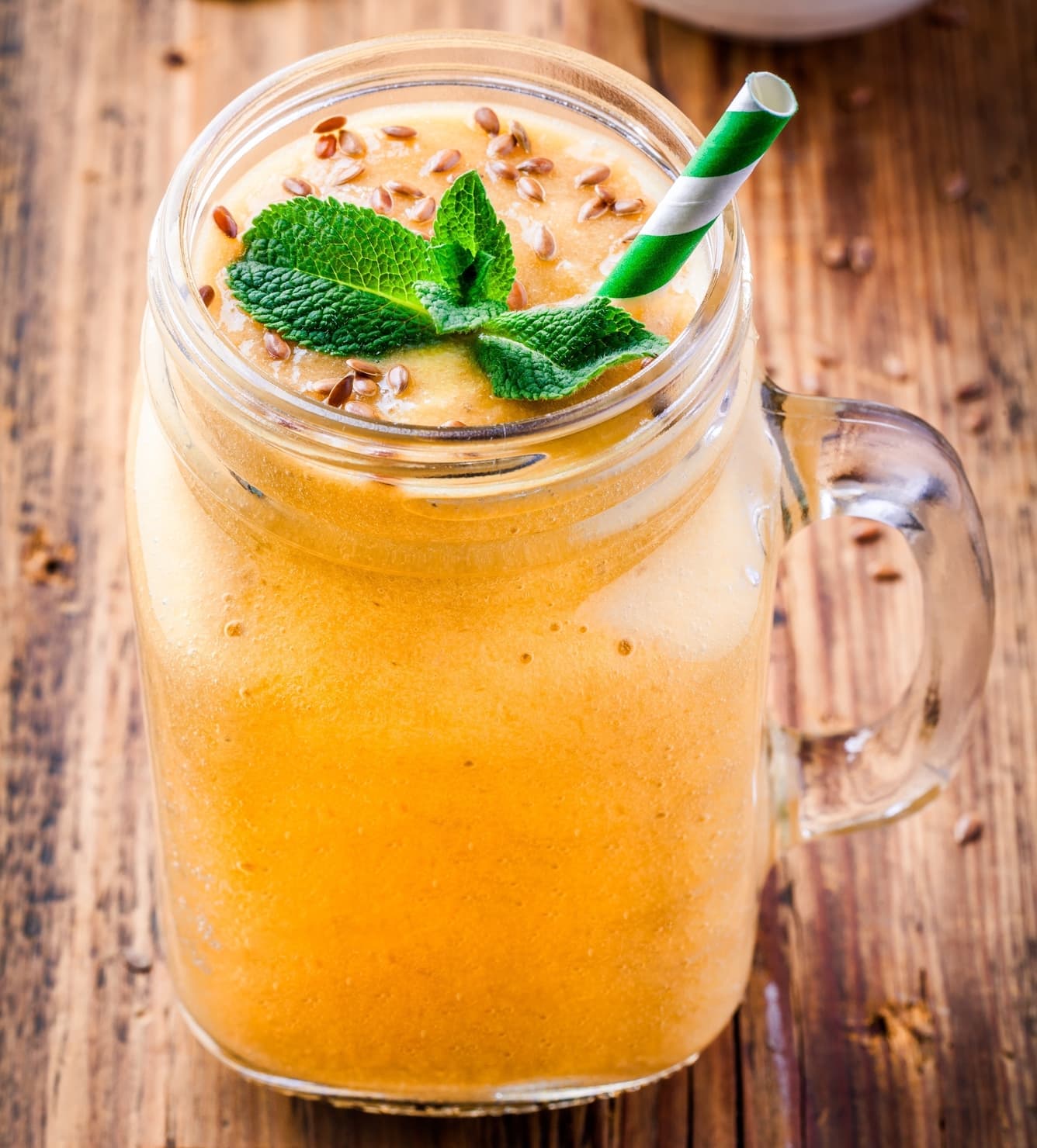 Caneca de sumo de laranja com sementes de linhaça, aromatizada com hortelã.