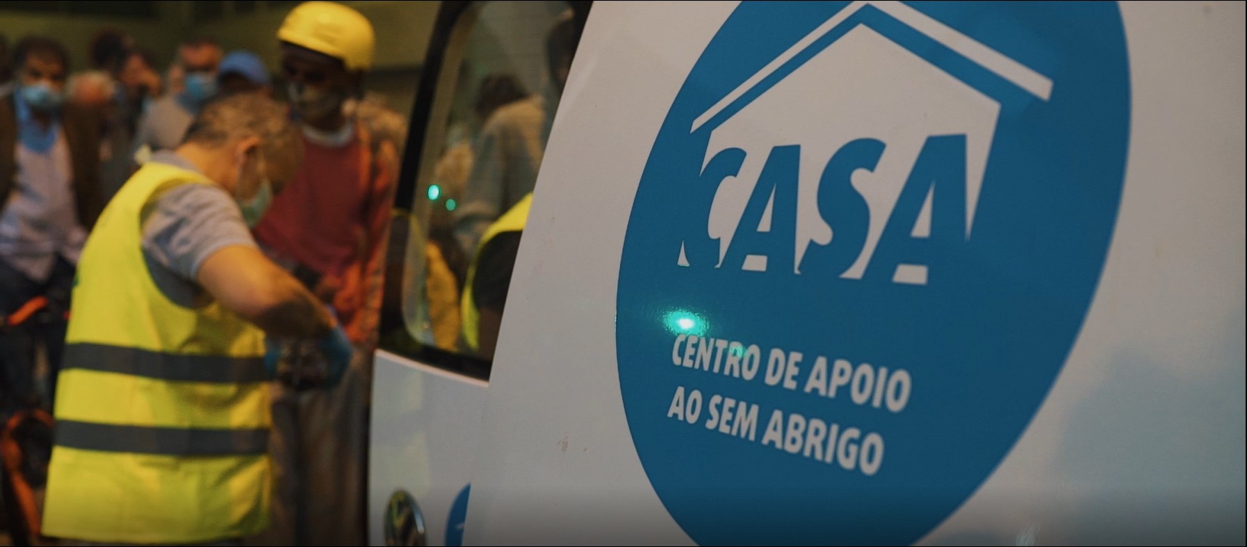 Lateral de carrinha do CASA - Centro de Apoio ao Sem Abrigo e colaboradores distribuindo comida.