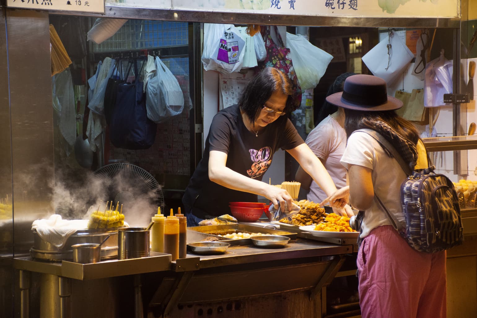 Mulher comprando comida em mercado Asiático.