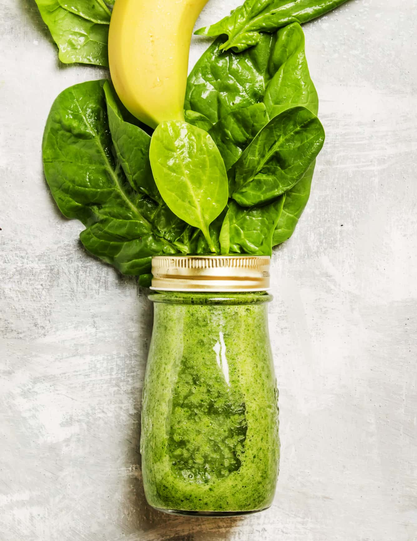 Banana peel and spinach smoothie in a jar.