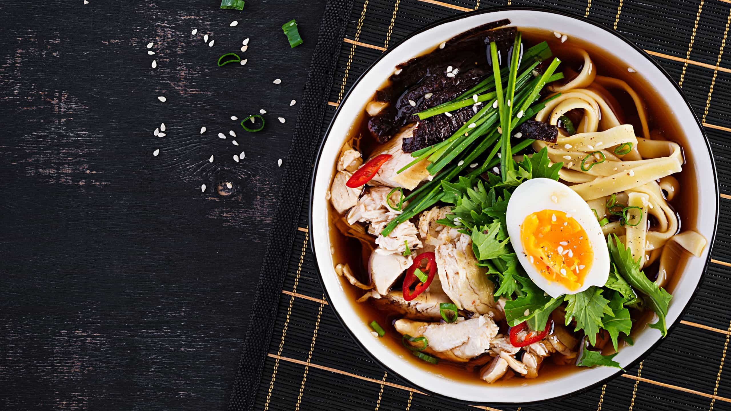 Metallic deep plate with ramen, a Japanese soup, with pasta, pork, egg, celery and seaweed.