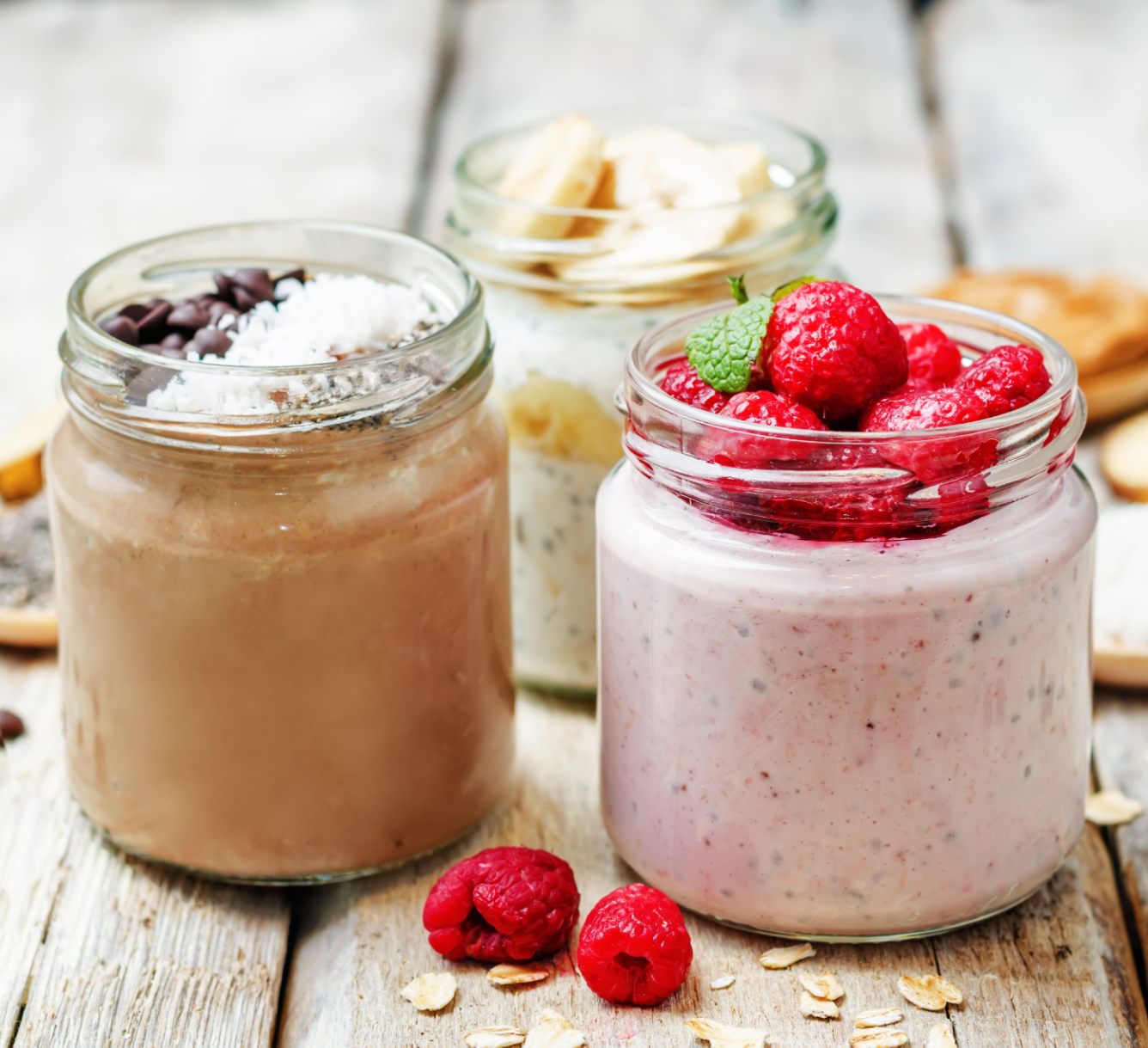 Three jars of overnight oats, on a wooden table.