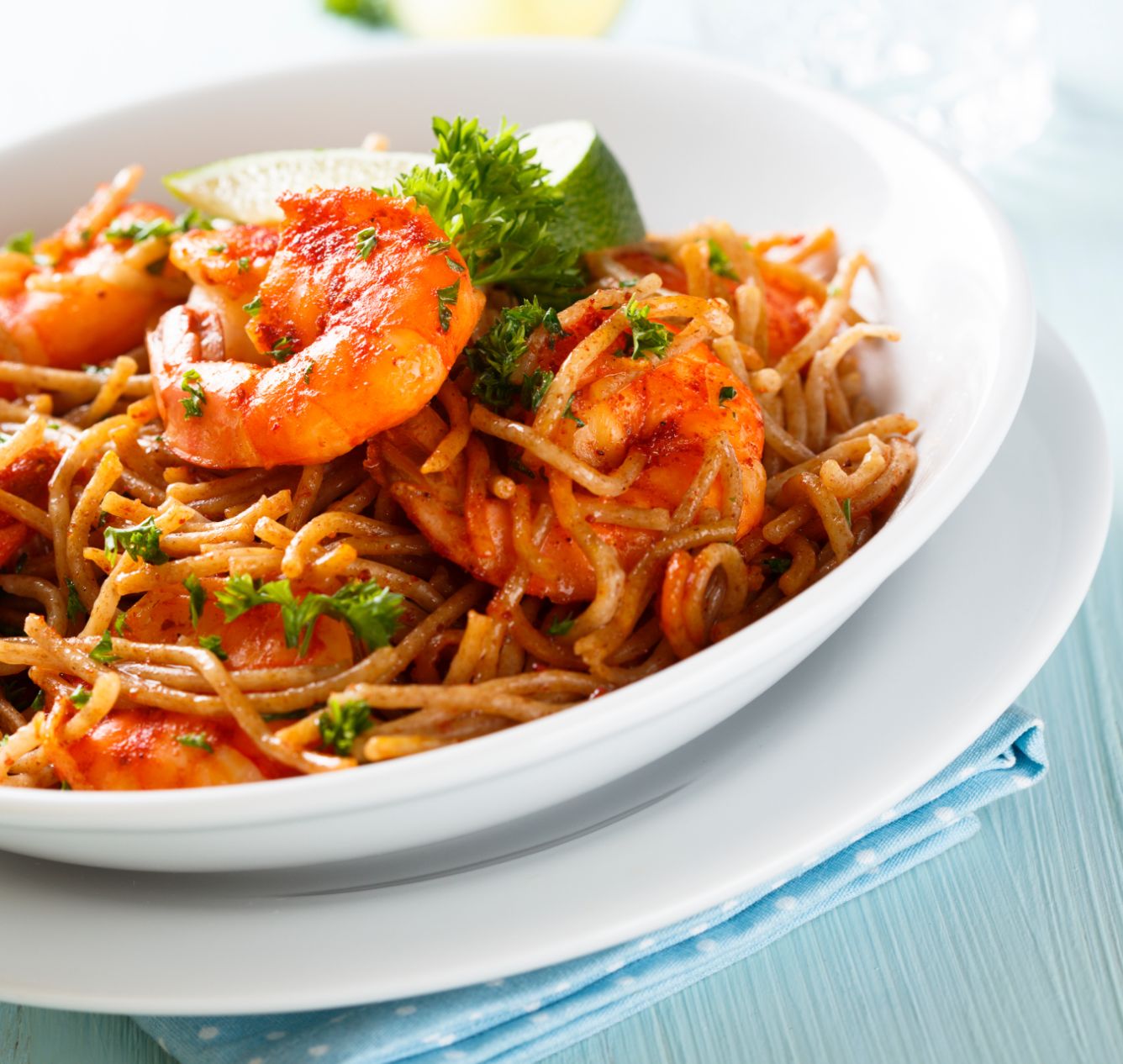 Ceramic deep plate with pasta with shrimps.