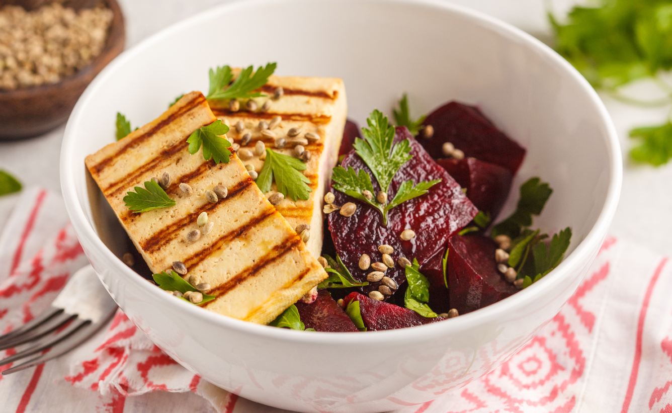 Grilled tofu with beetroot and parsley in a ceramic bowl.