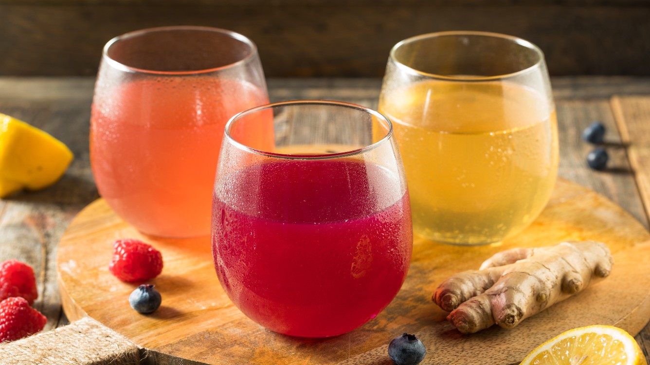 Three glasses with kombucha aromatised with different flavours.