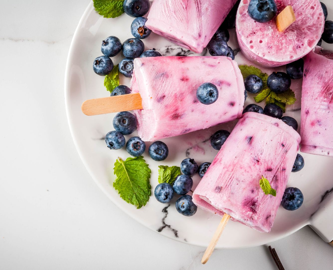 Blueberry and yogurt popsicles in a plate.