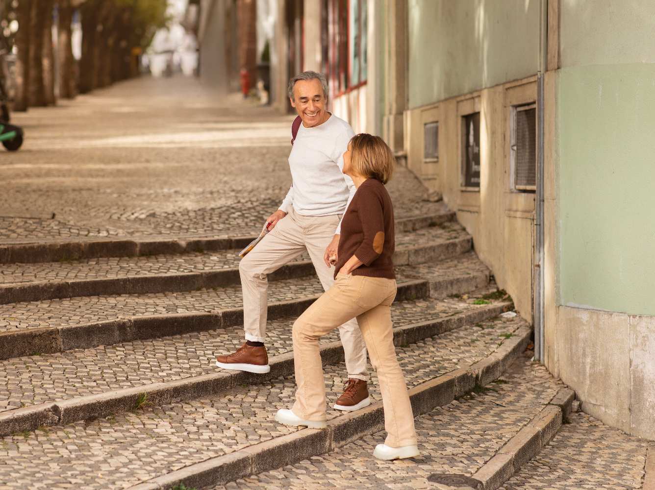 Homem e mulher subindo escadas em rua de Lisboa.