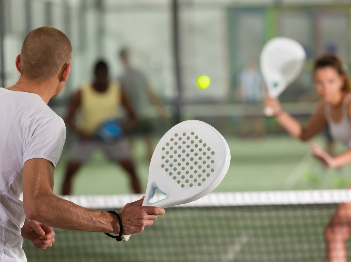 People playing padel in a court.