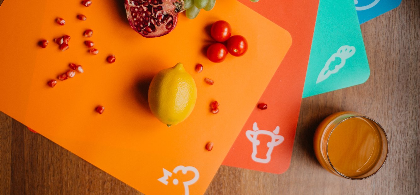 Rubber cutting board with lemon, cherry tomatoes and pomegranate