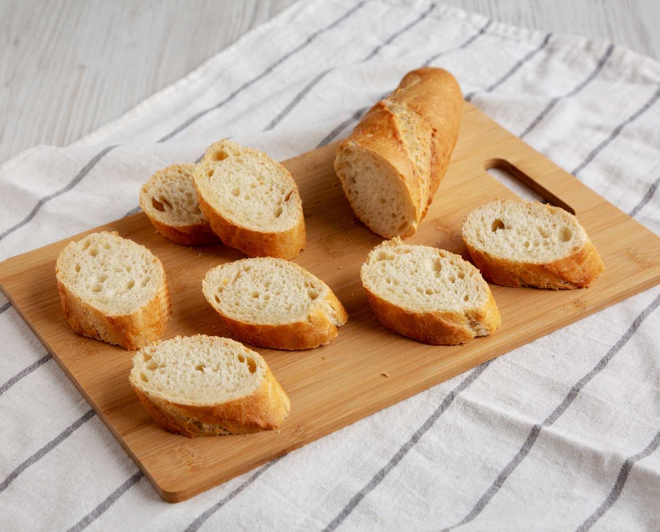 Tábua de corte de bambu com pão fatiado.