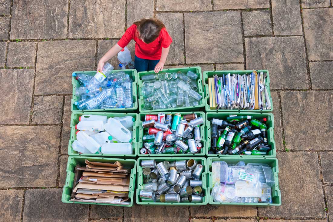 Caucasian teenage girl organizing recycling bins