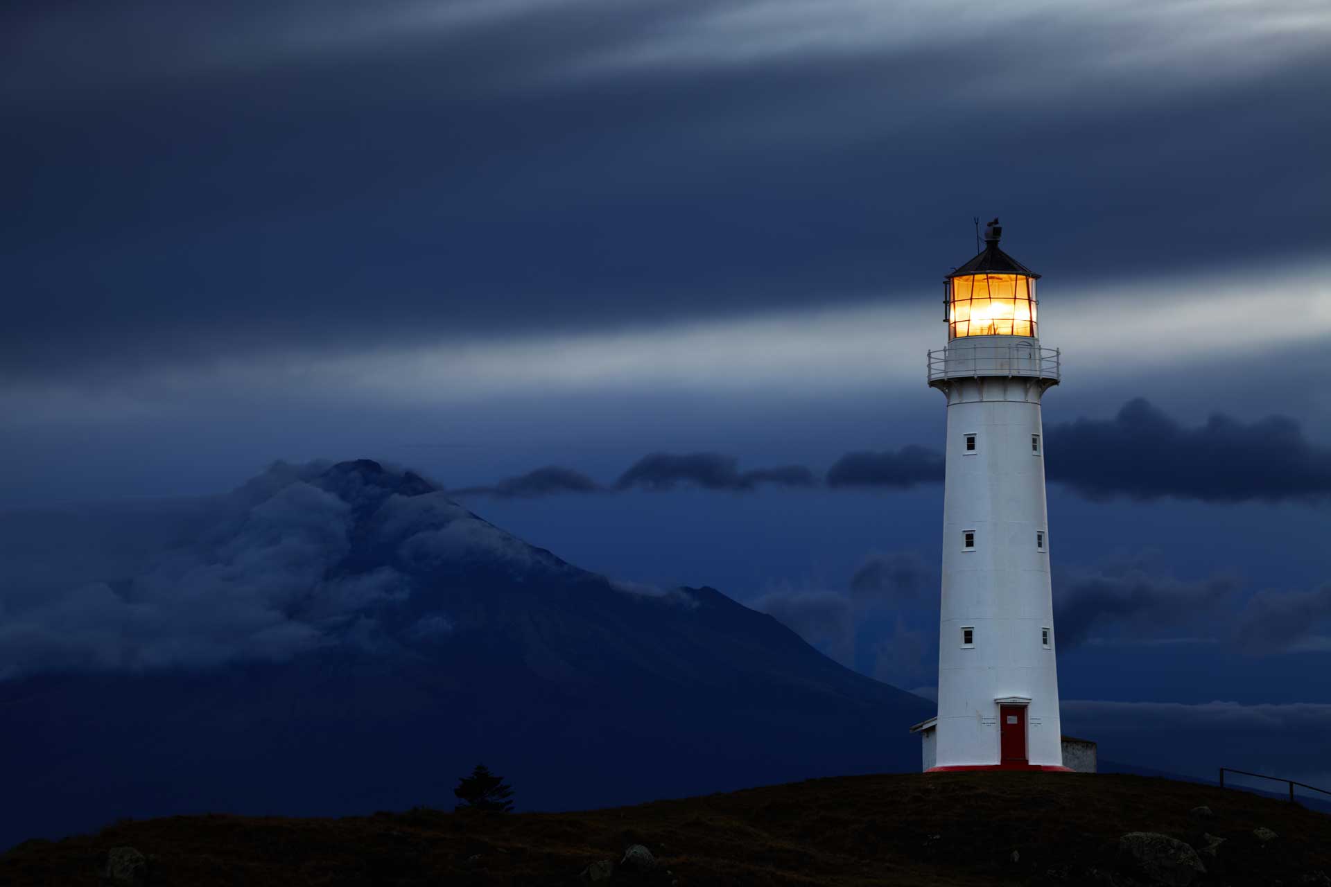 Cape Egmont Lighthouse and Taranaki Mount on background, New Zealand