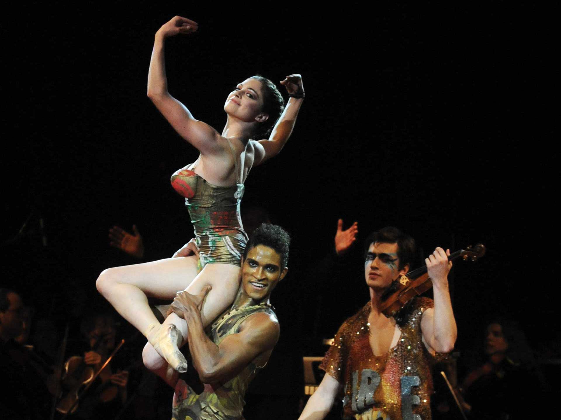 Dancers Fernando Montano and Romany Pajdek perform alongside violinist Charles Siem on stage during the catwalk showcasing Vivienne Westwood's Gold Label Collection