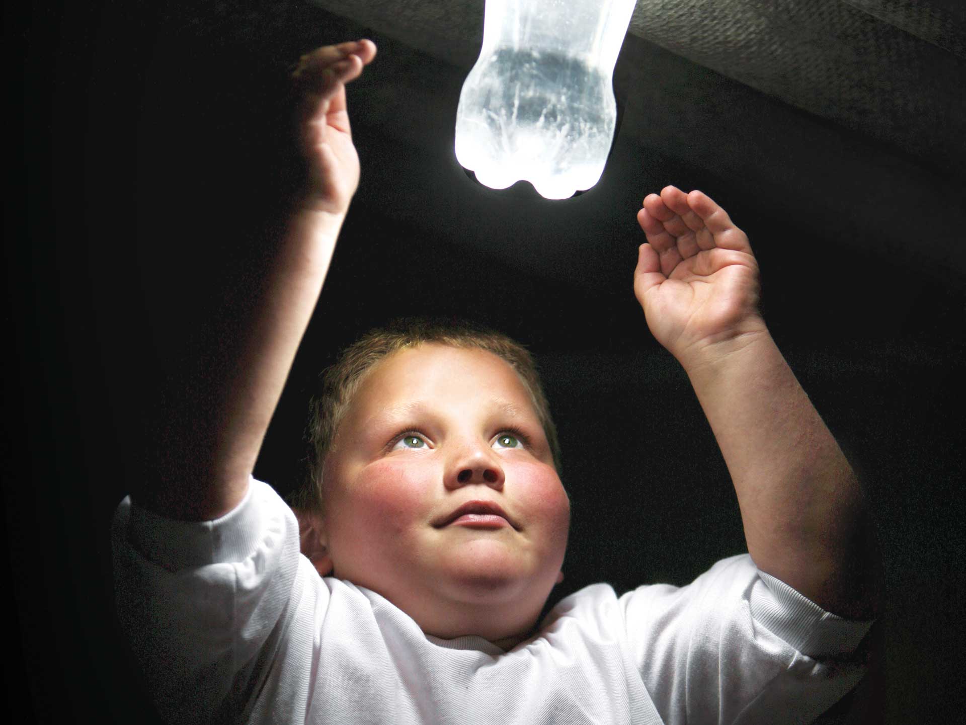 kid watching an illuminated bottle