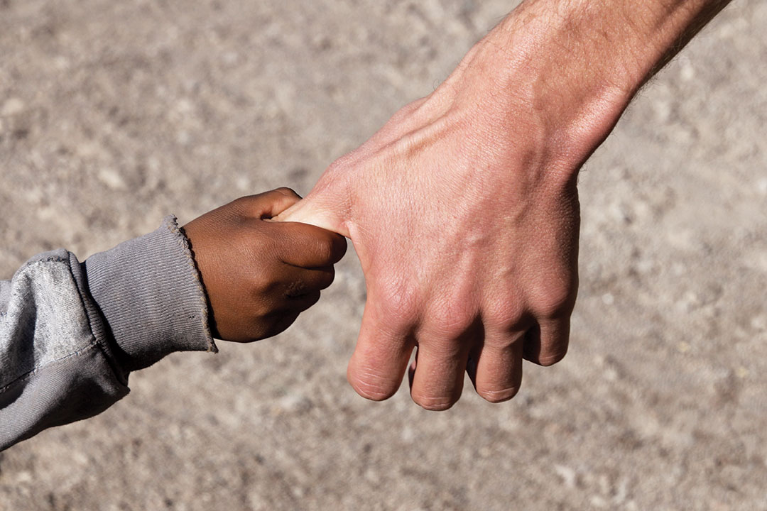 A Refugee child on Hand of a Helper