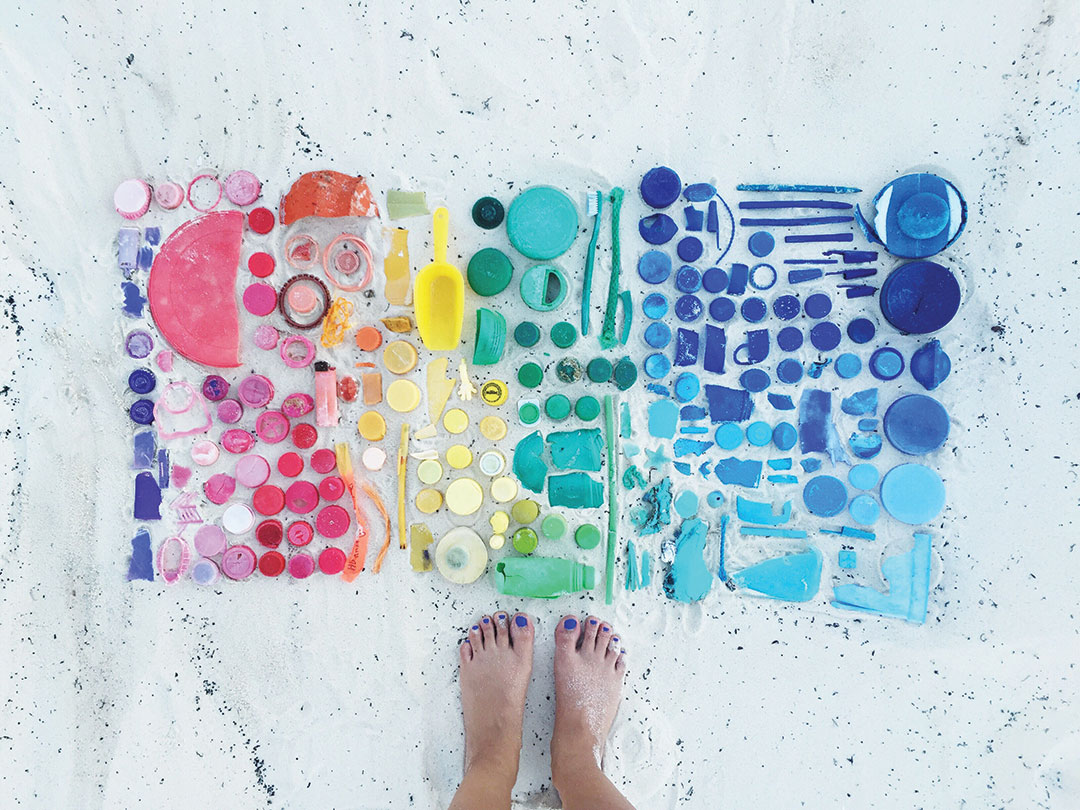 Low Section Of Woman Standing By Colorful Plastic Toys At Sandy Beach