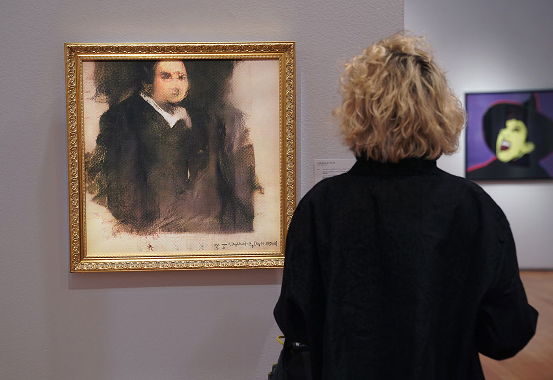 A woman looks at a work of art created by an algorithm by French collective named OBVIOUS which produces art using artificial intelligence, titled "Portrait of Edmond de Belamy" (estimate: $7,000-10,000) at Christies in New York on October 22, 2018.