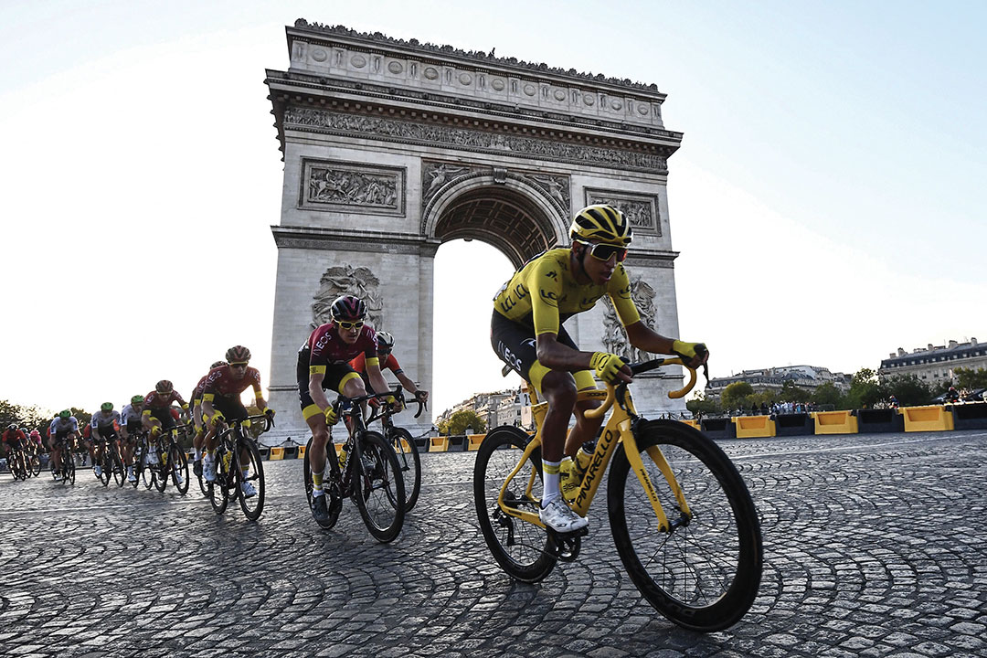 Colombia's Egan Bernal (R), wearing the overall leader's yellow jersey (C-R) and cyclists ride down the Champs Elysees avenue next to the Arc de Triomphe during the 21st and last stage of the 106th edition of the Tour de France cycling race between Rambouillet and Paris Champs-Elysees, in Paris, on July 28, 2019.