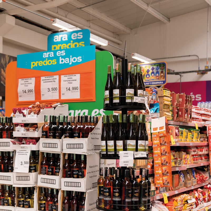 image of the inside of a supermarket, with wines and other products in exposition. 