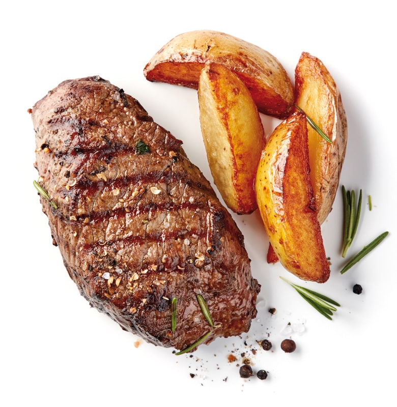  image from above of a steak with potatoes on the side, in a white background