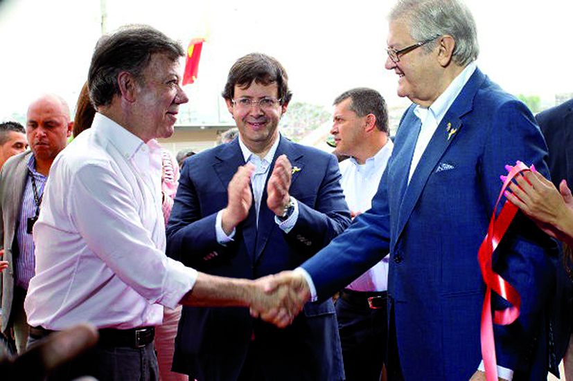 image of Former Colombian President Juan Manuel Santos (left) handshaking Alexandre Soares dos Santos (right), with Pedro Soares dos Santos (centre).