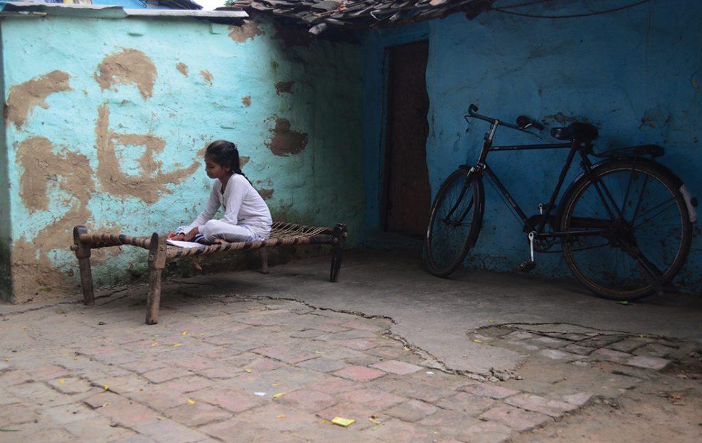 An Indian girl studies outside her house in slums on World Literacy Day , in Allahabad on September 8,2016.