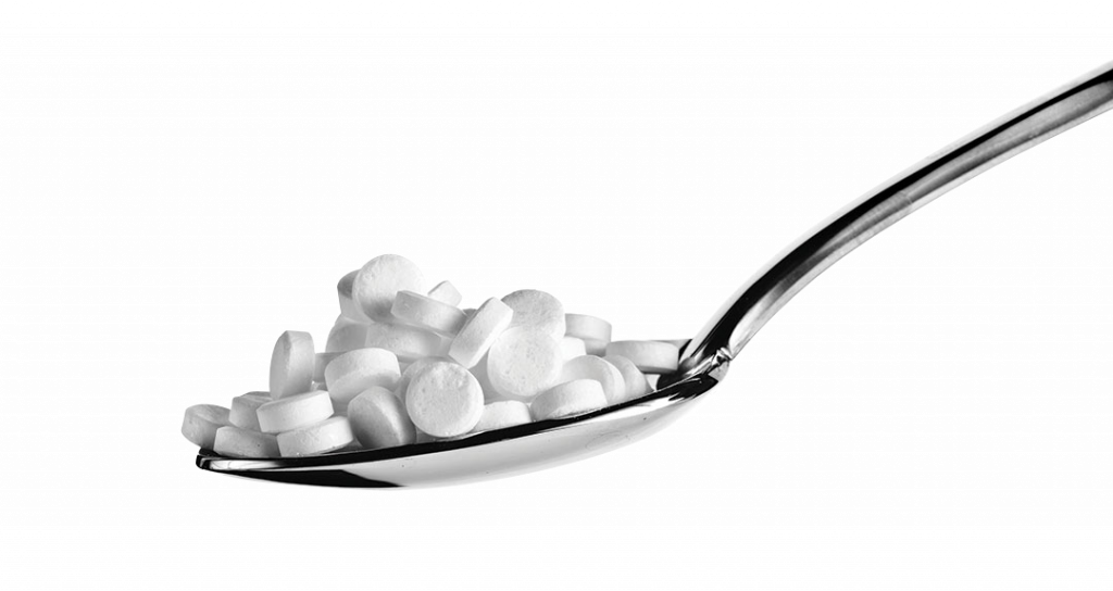 Sugar substitute pills in a spoon isolated