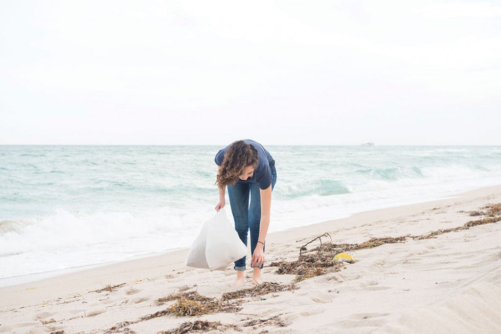 Environmentally Conscious Millennial Woman Cleans Up Beach