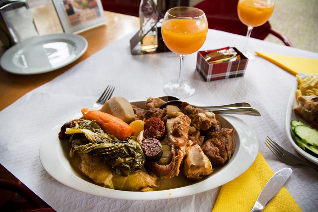 Typical and traditional azores food dish or dinner prepared by lowering the pot in a hot spring hole heated by volcanic steam for more than 5 hours, slow cooking with a lid weighted with stones on top