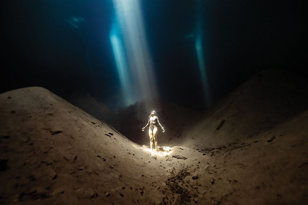 Sofia Gomez Uribe diving underwater with light