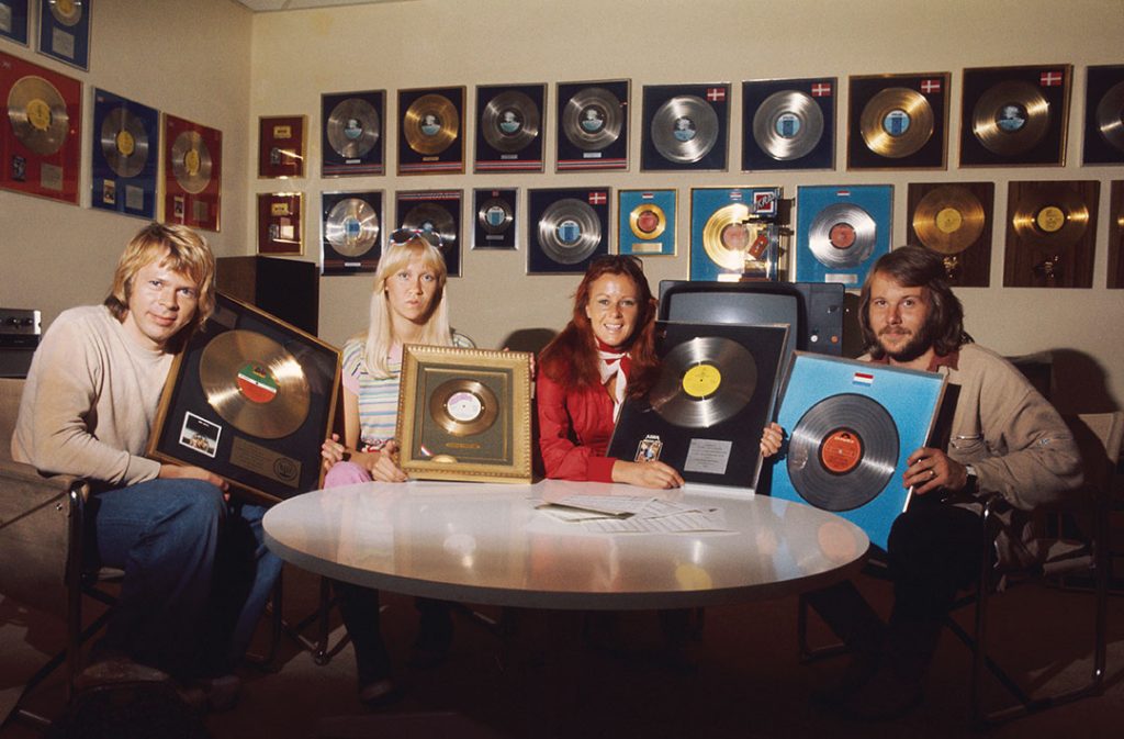 The ABBA posing in a room filled with their numerous gold records and platinum with, from left to right, Bjorn Ulvaeus and his wife Agnetha Faltskog, Anni-Frid Lyngstad (Frida called) and her husband Benny Andersson, each holding a disk frames.