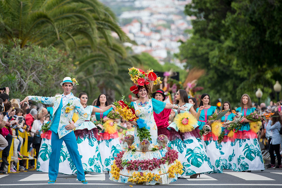 people dressed in colorful clothes at the Festa da Flor in city of Funchal on the island of Madeira.