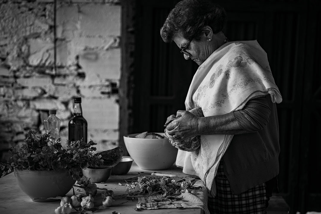 Black and white photography of Adelina Maria José, preparing a traditional dish, called Açorda