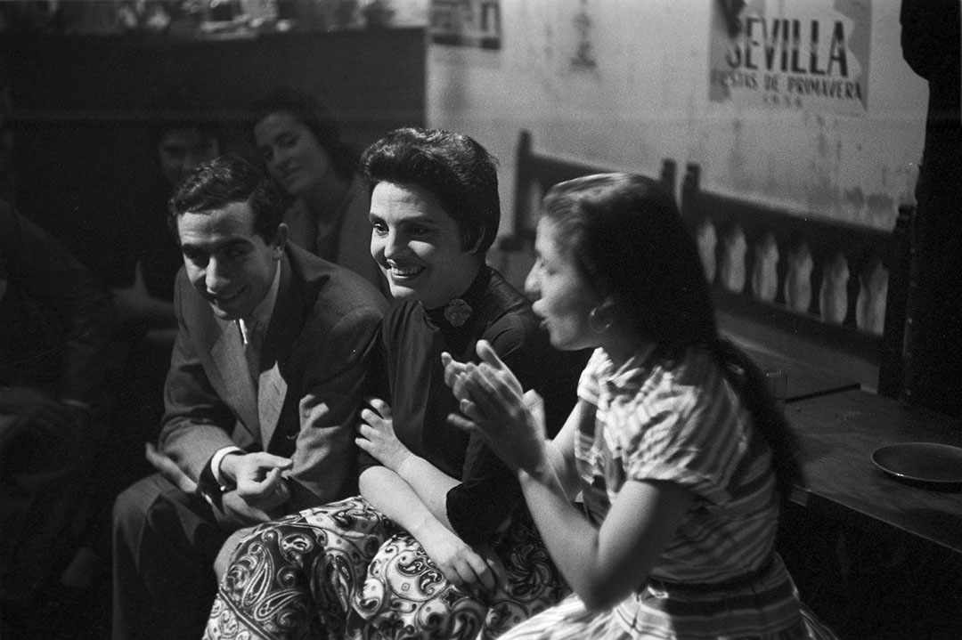 May 1956, at a club, a group of Spanish singers and singers, seated in a circle, sing a flamenco air, Among them, the singer Amalia Rodrigues (center). (Photo by Manuel Litran/Paris Match via Getty Images)