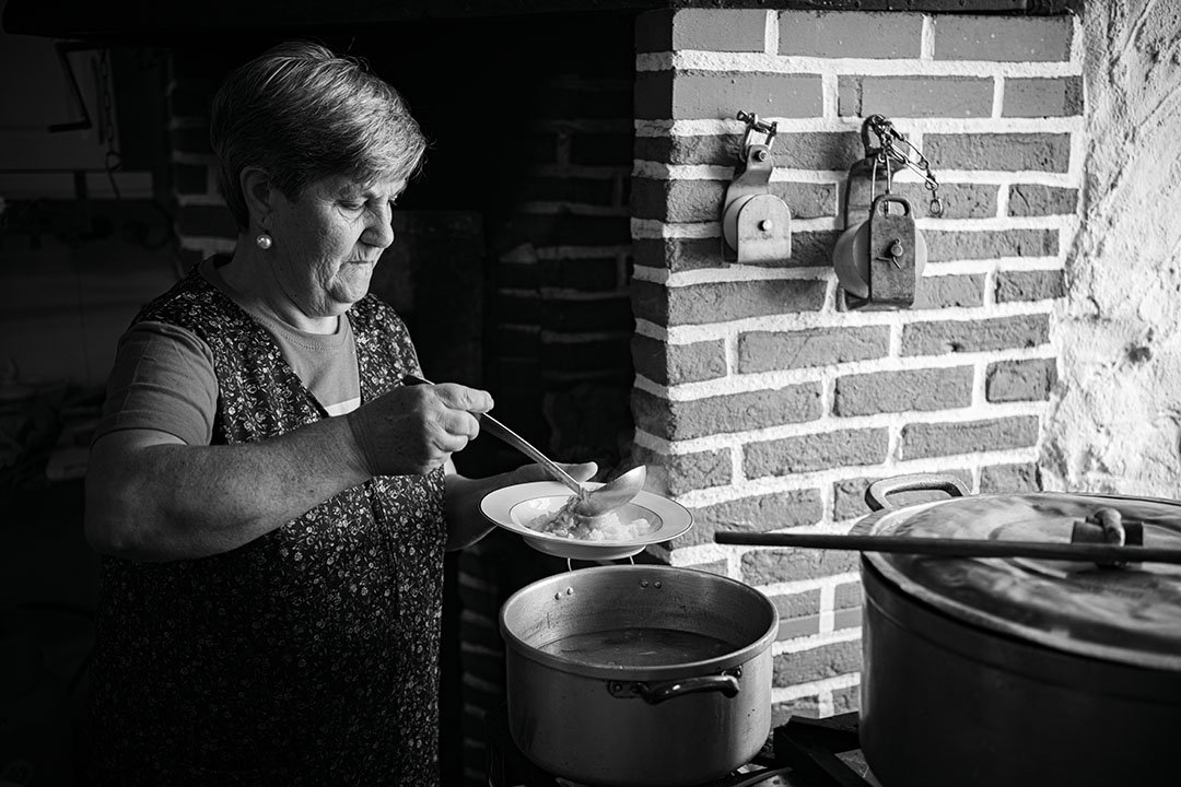 Black and white photography of a woman, Maria Laura, serving soup