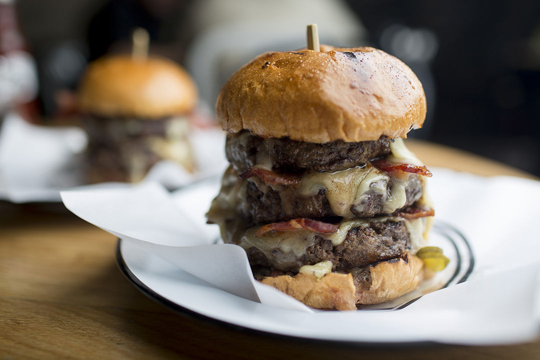 Hamburgers sit on a table in an arranged photograph at Beef & Liberty restaurant in Hong Kong, China, on Thursday, Sept. 4, 2014. Burger sales in Hong Kong grew 6.4 percent last year, more than double the rate of U.S. growth, and are forecast to grow another 6 percent this year, to $786 million, compared with 4.3 percent growth in the U.S., according to data provided by research firm Euromonitor International. Photographer: Brent Lewin/Bloomberg via Getty Images