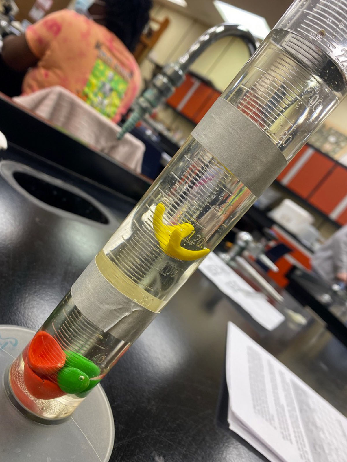 Clay plankton sinking in graduated cylinder of corn syrup