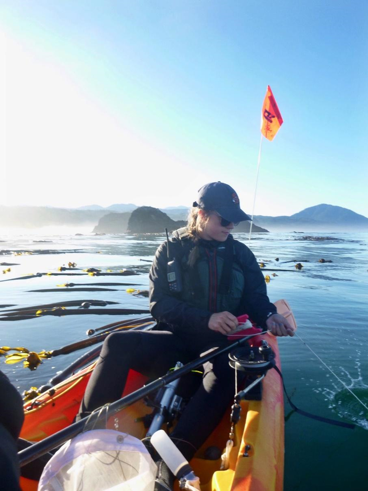 Student conducts prey sampling from a kayak