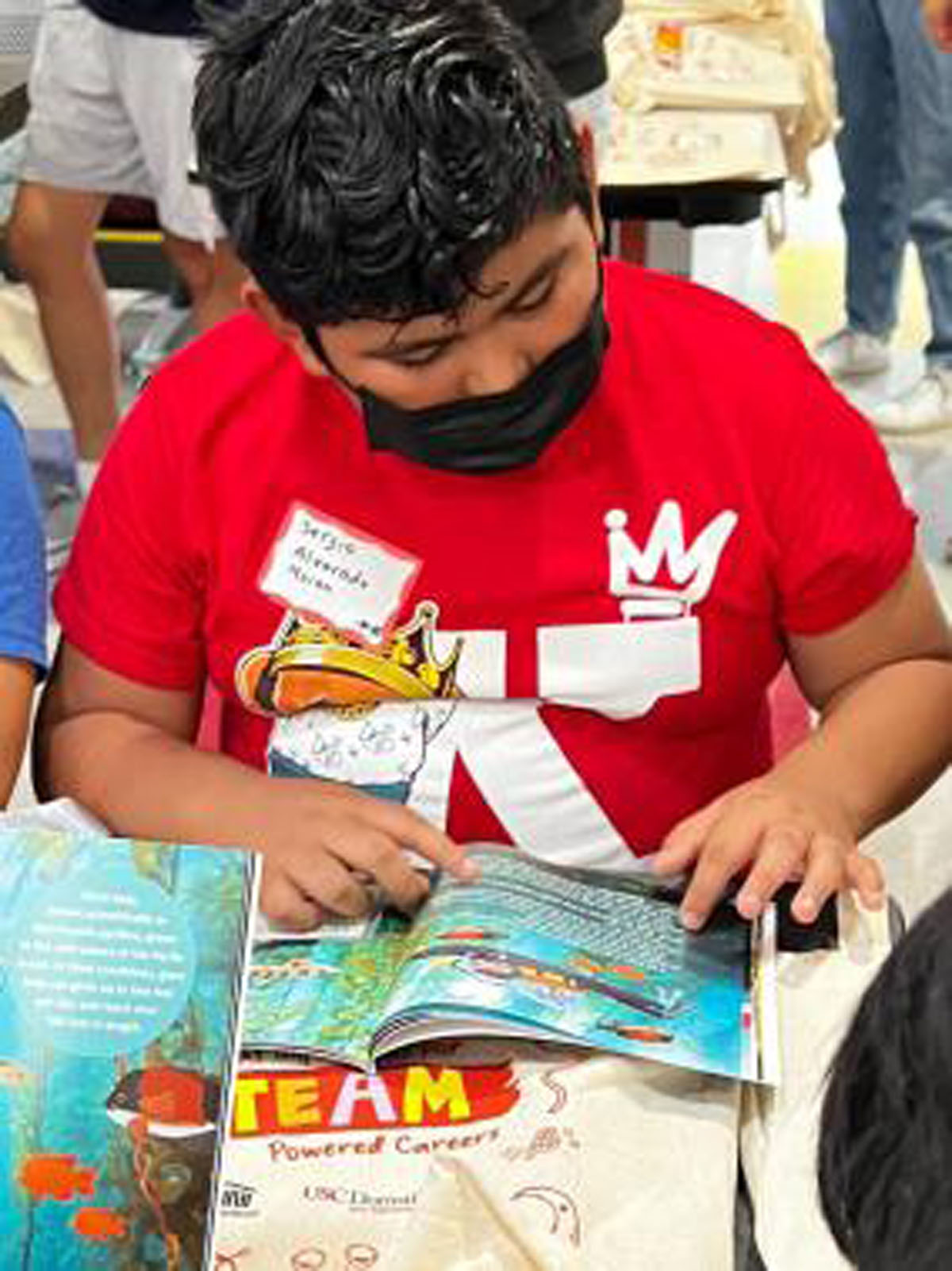 A young student examines the kelp forest page of the marine biology book. Kelp forests are a native habitat to California, photo taken by Dieuwertje Kast, permission to be reproduced