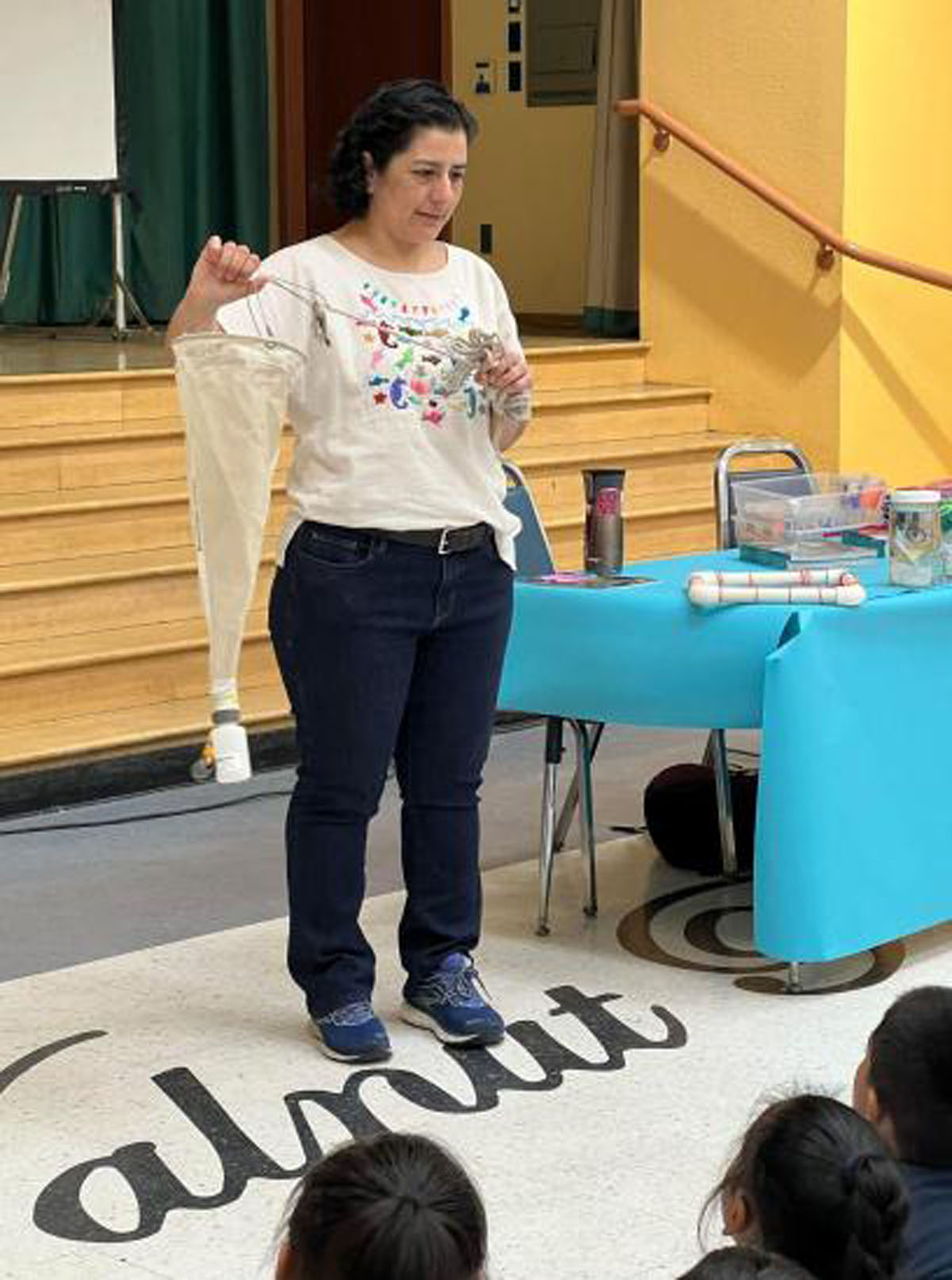 Maria holding plankton tow net at book assembly, photo by: Patricia Valencia, permission to be reproduced