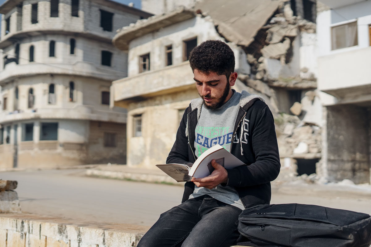 A Syrian student of Idlib University reading a donated book