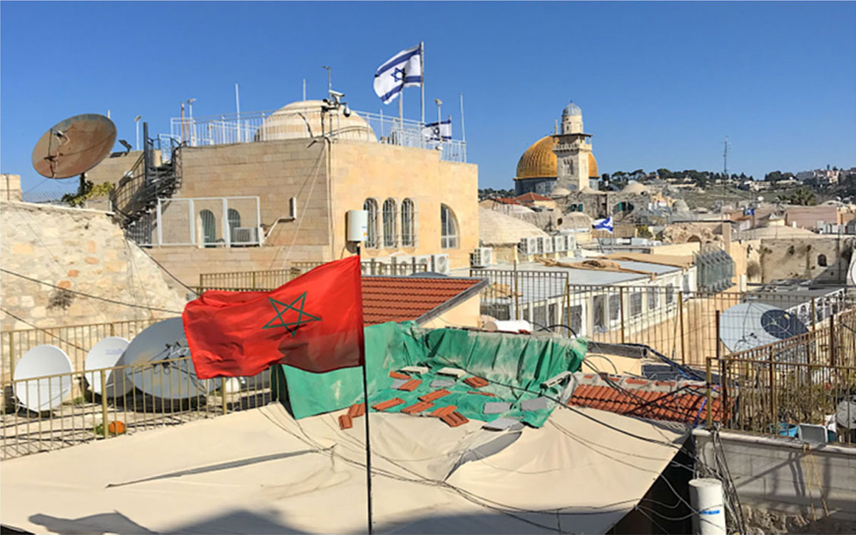 Moroccan flag on a roof with Israeli flag and Dome of the Rock in the background