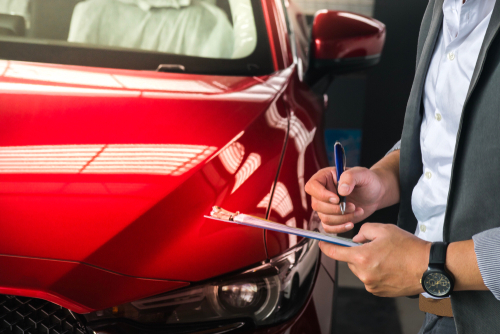 A mechanic writing down mileage.