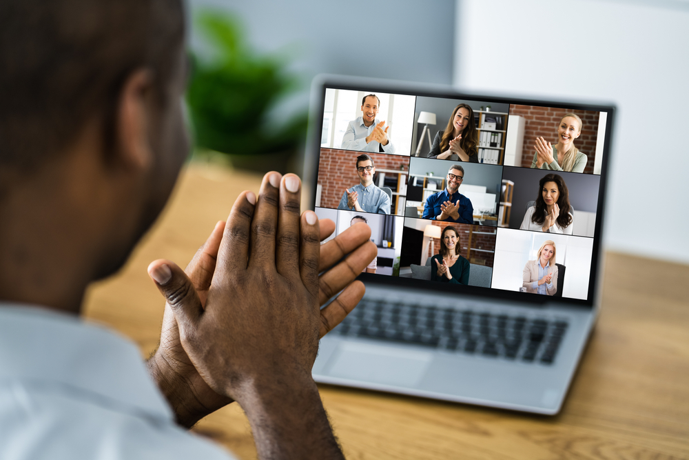 Team clapping during virtual video conference call on computer.