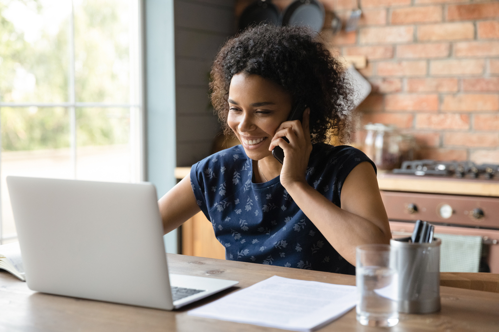 Woman working on a laptop and making calls.