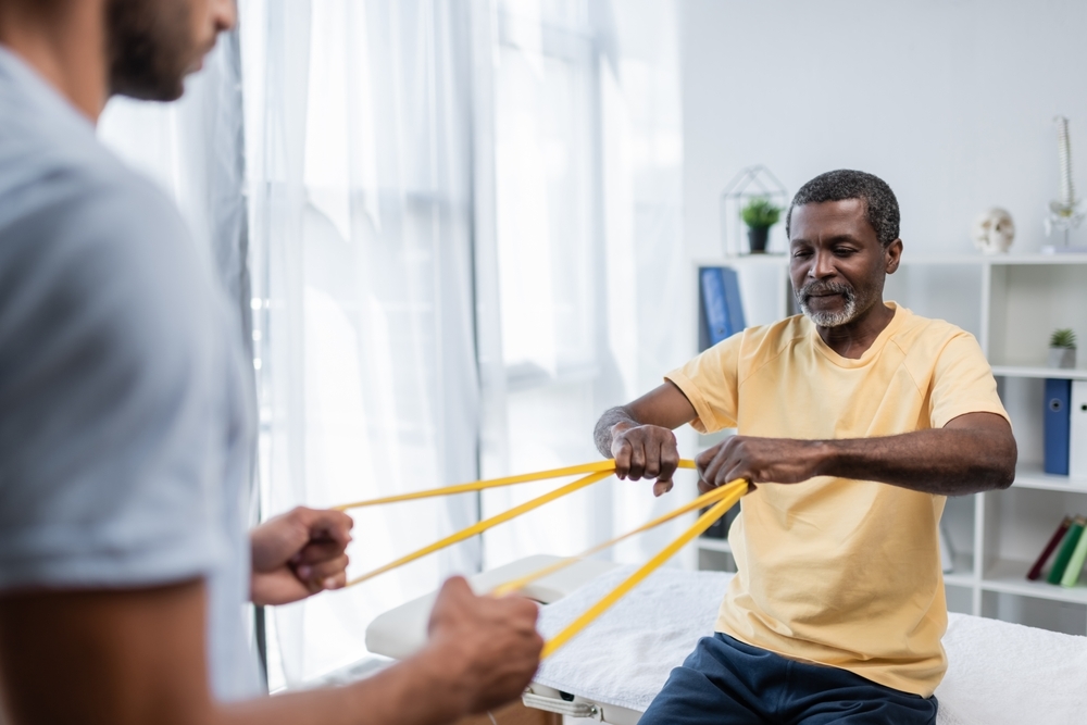 A man being worked on by a physical therapist.