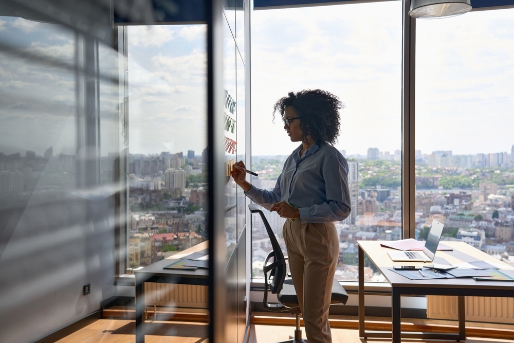 Young female professional writing on a white board.