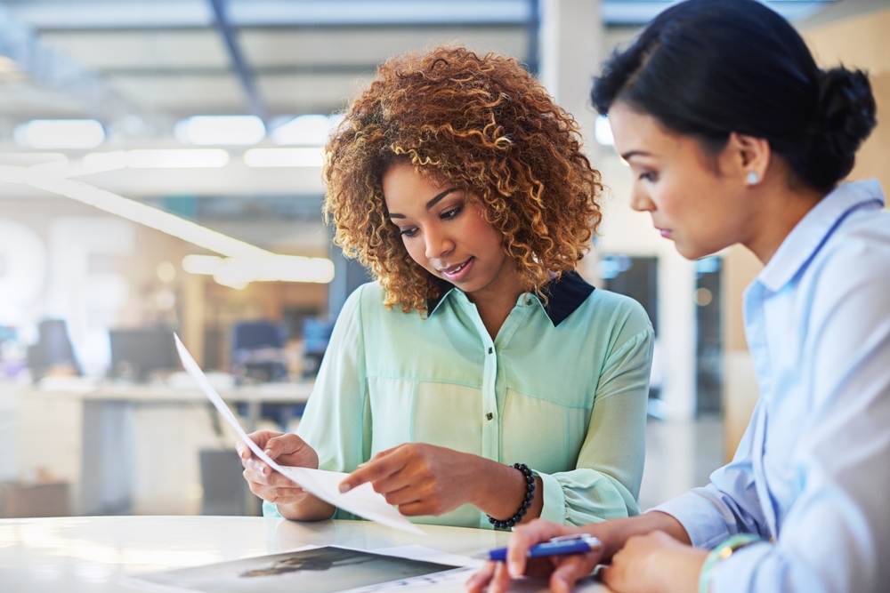 Hiring manager and young woman going over a resume.